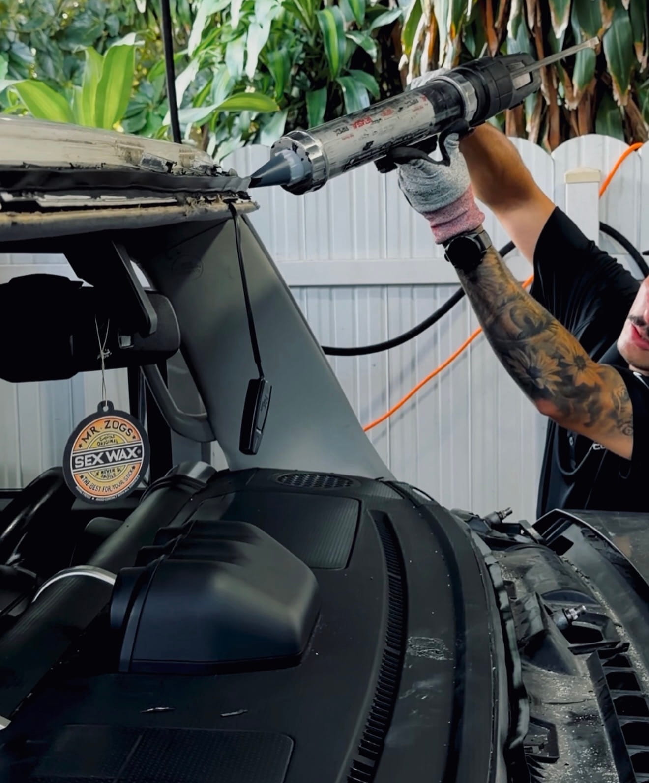 Técnico móvil aplicando uretano para instalar un parabrisas en Miami